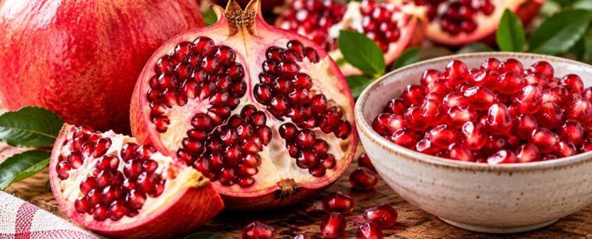 Melograno aperto e chicchi sgranati in una ciotola