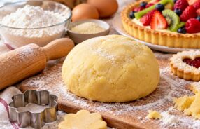 Panetto di pasta frolla senza glutine con mattarello, formine e crostata di frutta